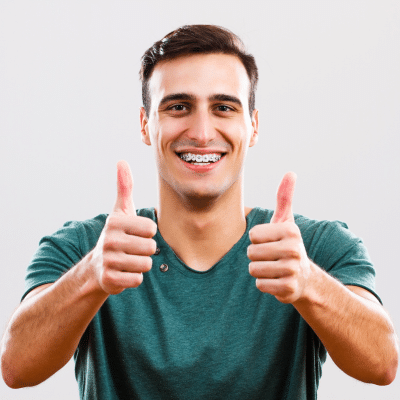 Man smiling and giving two thumbs up, representing braces for adults