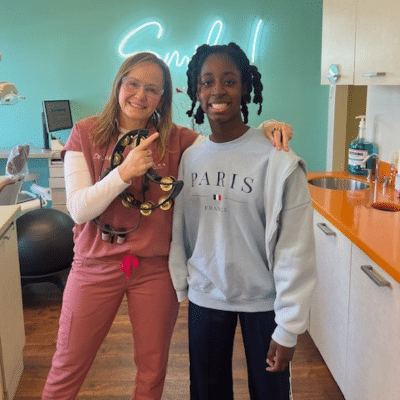 Dr. Minera posing with a teenage patient, representing how clear aligners work