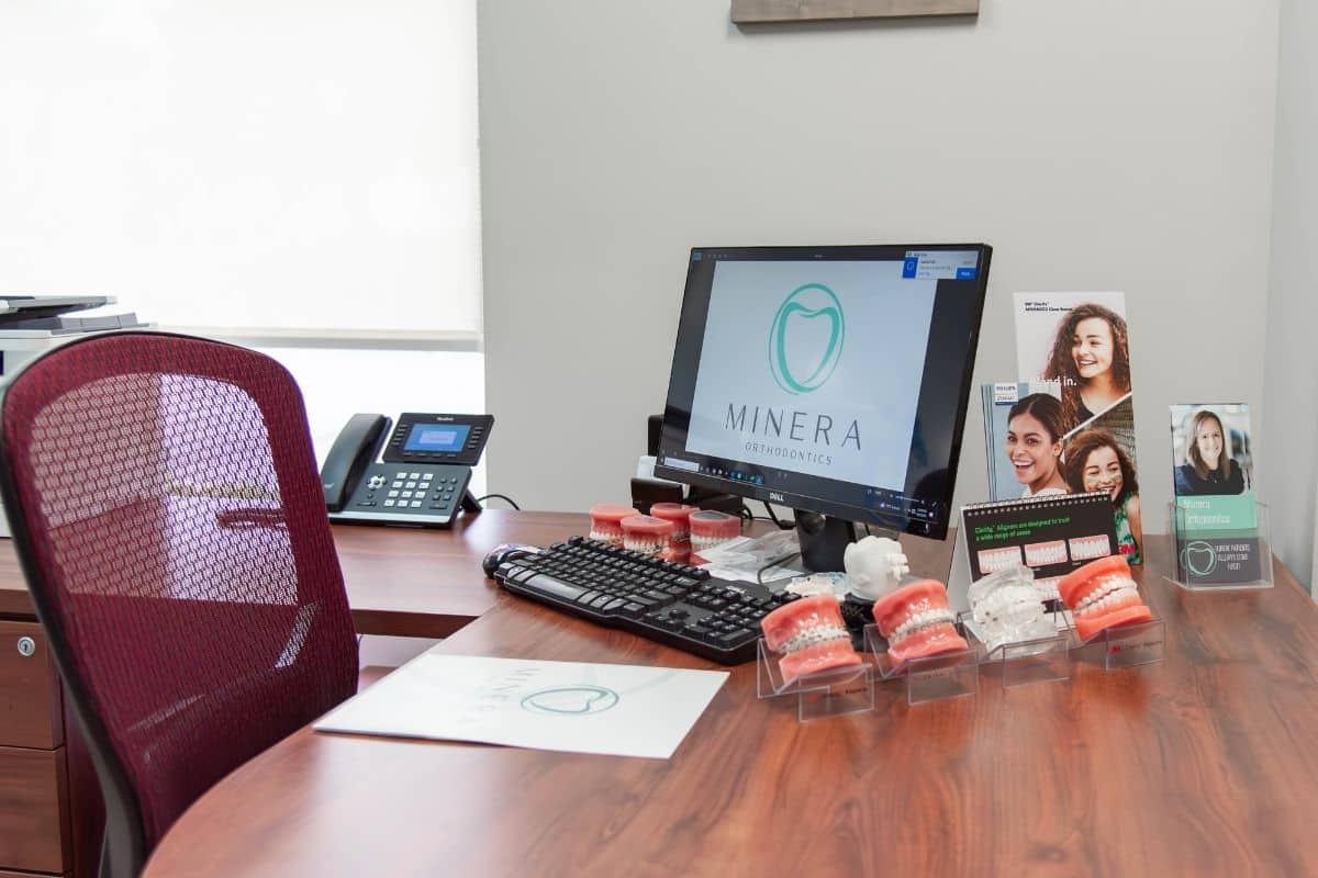 Orthodontic consultation desk with clear aligner and braces models at minera orthodontics in warrenton, virginia